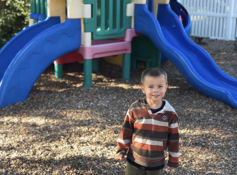 Child in front of playground slides at Toad Hall